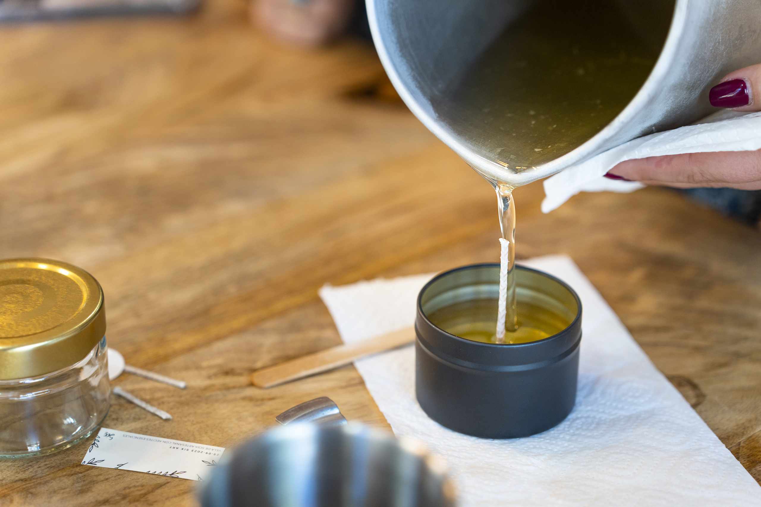 Woman pouring melted wax in a warm workshop